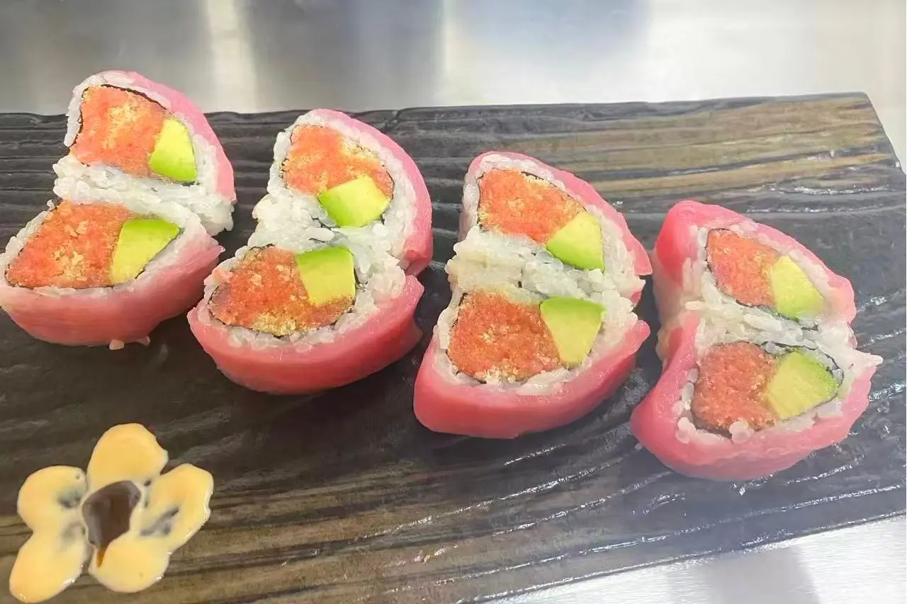 Sushi rolls wrapped in pink - colored material with avocado and fish filling at Dharma Sushi & Grill, a Japanese Restaurant in Schenectady