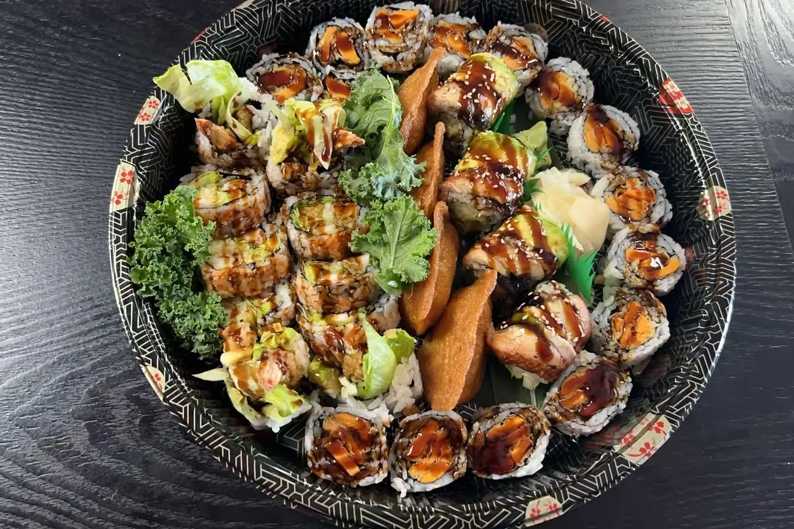 A large assortment of sushi rolls, decorated with greens at Dharma Sushi & Grill, a Japanese Restaurant in Schenectady